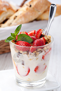 酸奶与格兰诺拉麦片和草莓在玻璃图片