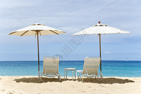 两把白色沙滩椅和雨伞图片