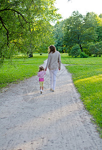 母亲和孩子在公园里散步后视图图片