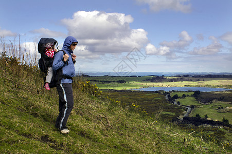 母亲和婴儿在山上背着行李图片