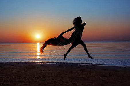 在美丽的日落期间在海上飞行的女人的剪影自然光与暗添加图片