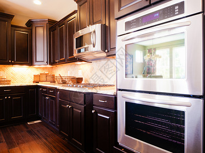 现代厨房配有深色木橱柜和硬木地板图片