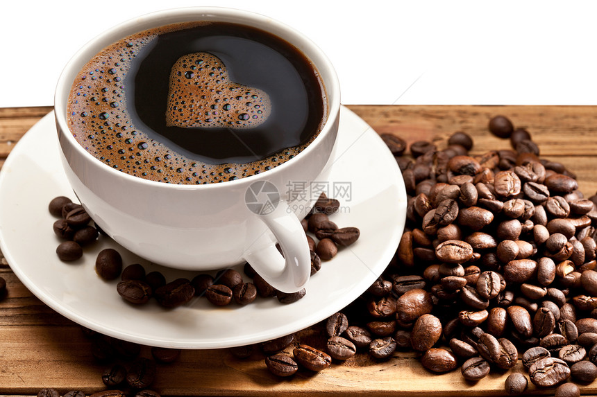 咖啡杯和茶碟放在木制桌上以心脏的图片