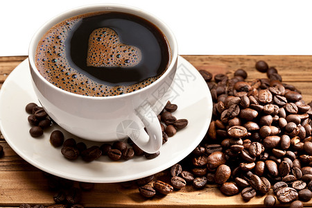 咖啡杯和茶碟放在木制桌上以心脏的高清图片