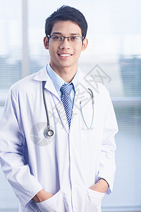微笑的男临床医生和听诊器的肖像在医院图片