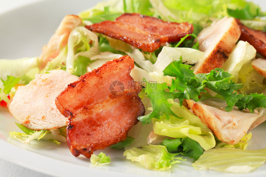 绿色沙拉配鸡胸肉片和炸盐猪肉图片