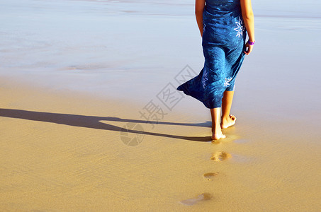在海滩上赤脚走着蓝裙图片