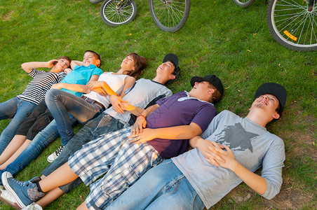骑自行车后躺在草地上的少年男女儿童图片