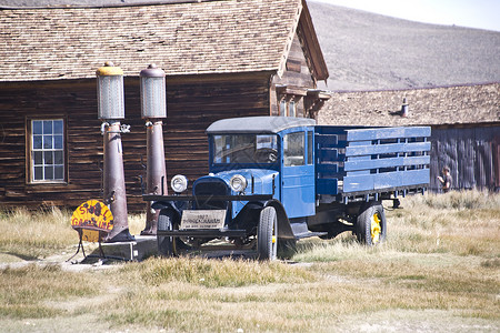 加州金矿鬼城的古老煤气泵旁有个旧卡车图片