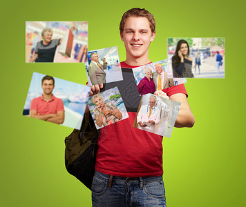 青年男子持有绿色背景照片的数字平板图片
