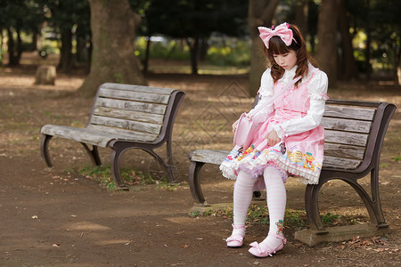 悲伤的日本洛丽塔角色扮演时尚坐在长凳上图片