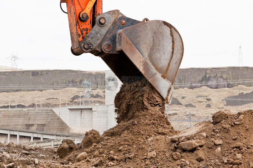 在建筑工地卸下一块石头的泥土的后蹄机器图片