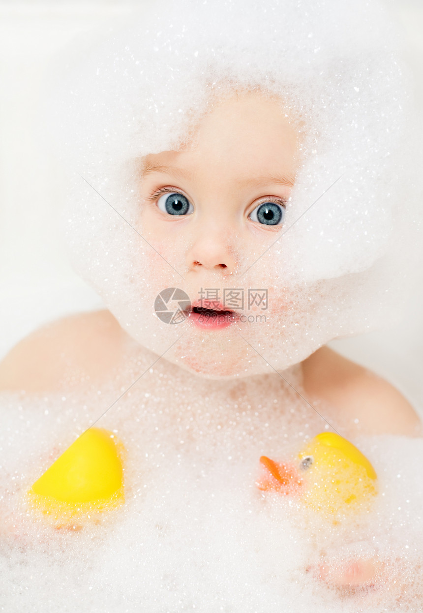 用橡皮鸭沐浴在肥皂水中的小女婴图片