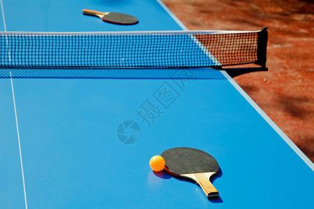 乒乓球与乒乓球桌上的桨图片