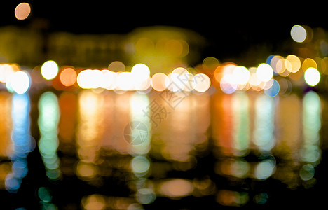 沿海城市夜晚的灯光在暗海中反射出来打破了许多明亮背景图片