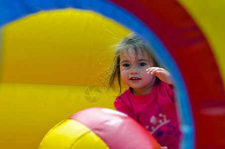 快乐的女孩跳上一个儿童充气充图片