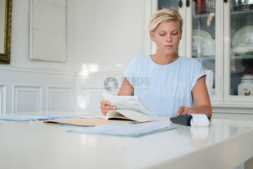 家庭财务个人储蓄和财务规划年轻的白人女检查账单并用计算图片