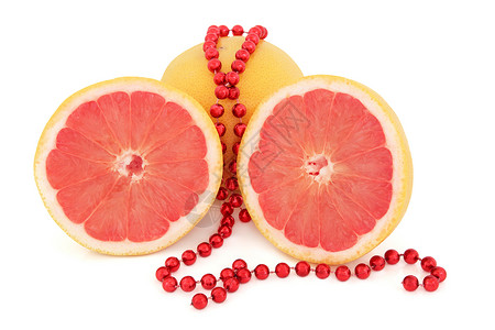 红宝石红葡萄柚整体和一半与串珠在白色背景图片