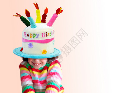 漂亮的小女孩笑着头顶戴着一顶大生日帽子图片