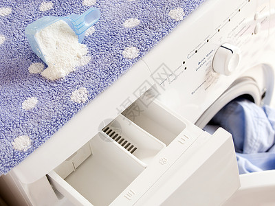 用于洗涤概念的带有洗衣粉的洗衣机图片