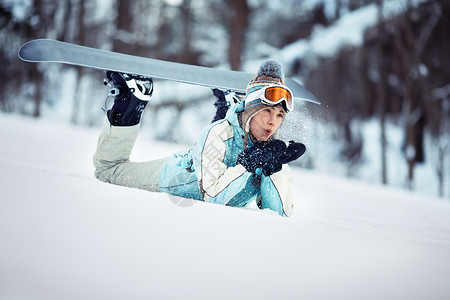 年轻漂亮的女滑雪者在滑雪坡上休息图片