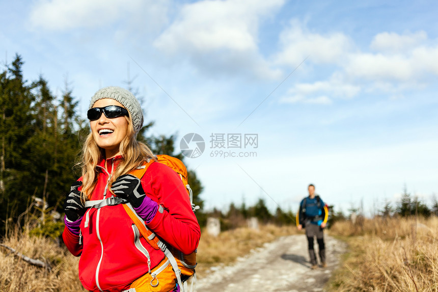 男人和妇女徒步旅行者在山径上漫步秋天或冬季自然波兰森林里走的年轻夫妇图片