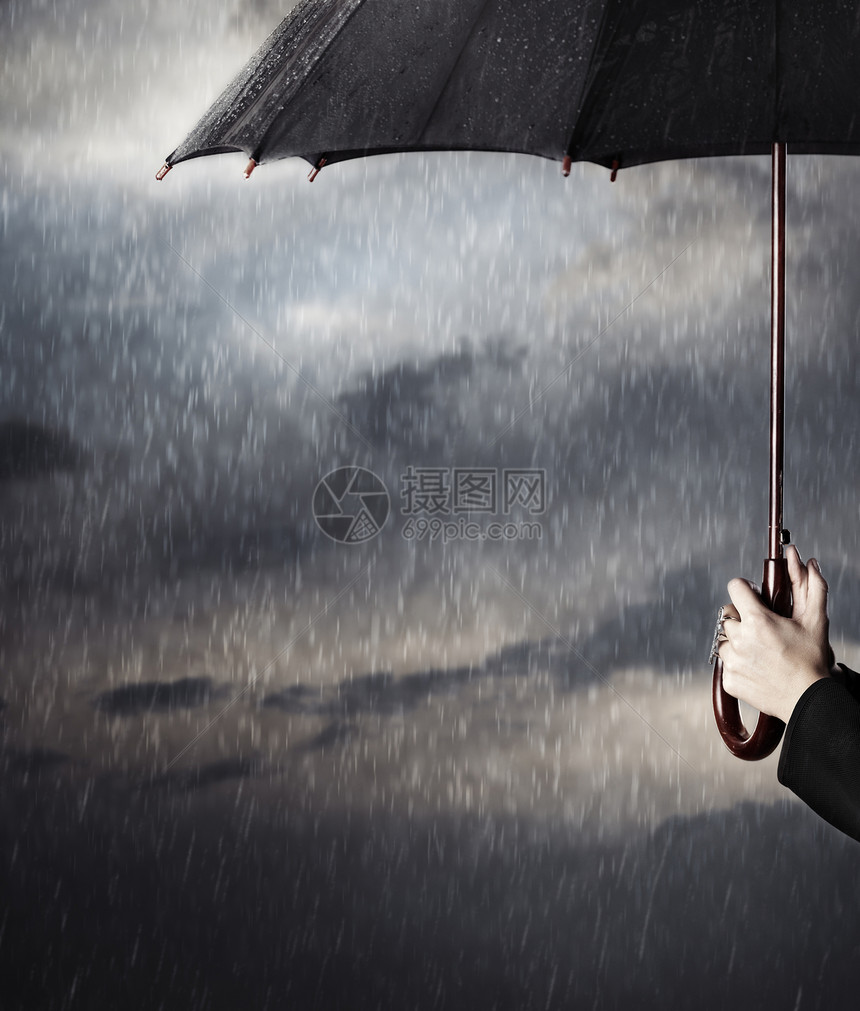 大雨下人手拿着大黑伞图片