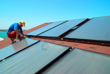 屋顶上的工人太阳能热水板高清图片