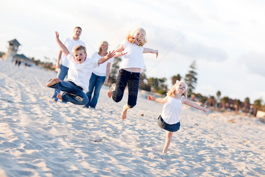 快乐的兄弟姐妹儿童跳跃欢乐在海滩图片