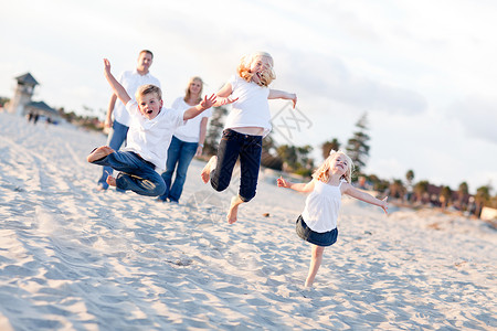快乐的兄弟姐妹儿童跳跃欢乐在海滩图片