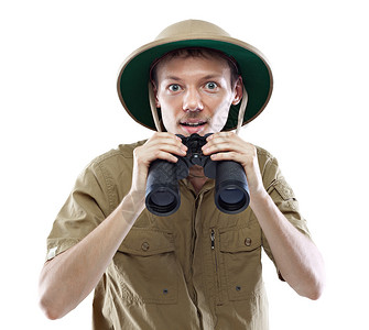 身着狩猎衬衣和皮帽头盔的青年男子降低双目望远镜图片