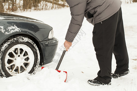 从雪地里挖车的人图片