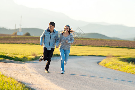 青少年夫妇在农村公路上奔跑图片