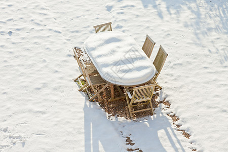 被雪覆盖的木制花园家具顶视图图片