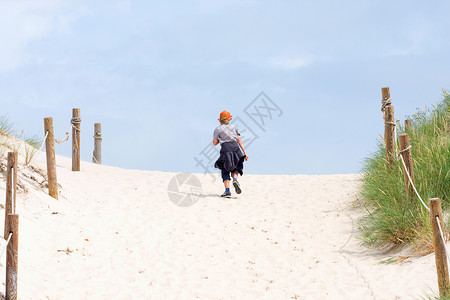 走通过沙丘的孤独的男孩图片
