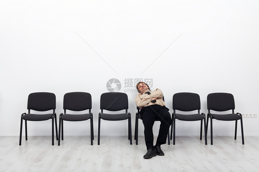 疲劳的商人等待坐在椅图片