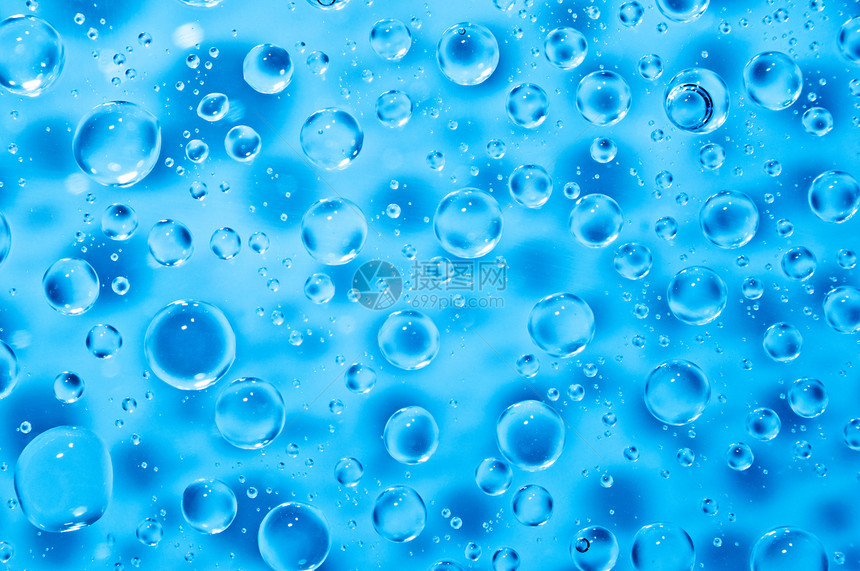玻璃上大小水滴的蓝色水背景图片