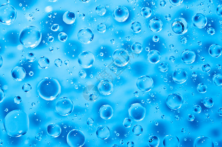 玻璃上大小水滴的蓝色水背景图片