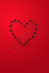 痴情爱的概念红纸背景上水滴的心形背景
