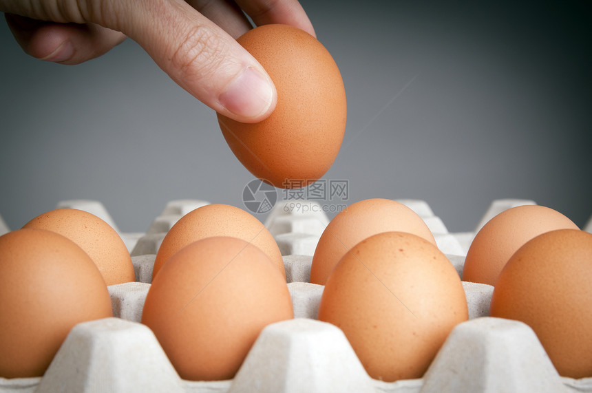 从一盒鸡蛋中挑选最好鸡蛋的人图片
