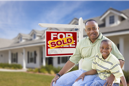 非裔美国人父亲和儿子在出售不动产标牌和新房子的图片