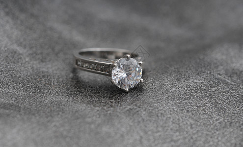 灰色纹理背景上的优雅订婚戒指图片