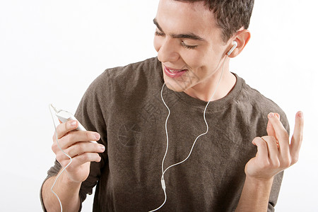 近距离的肖像一个吸引人的喜悦男人用耳机收听和跳舞音乐在白色背景下图片