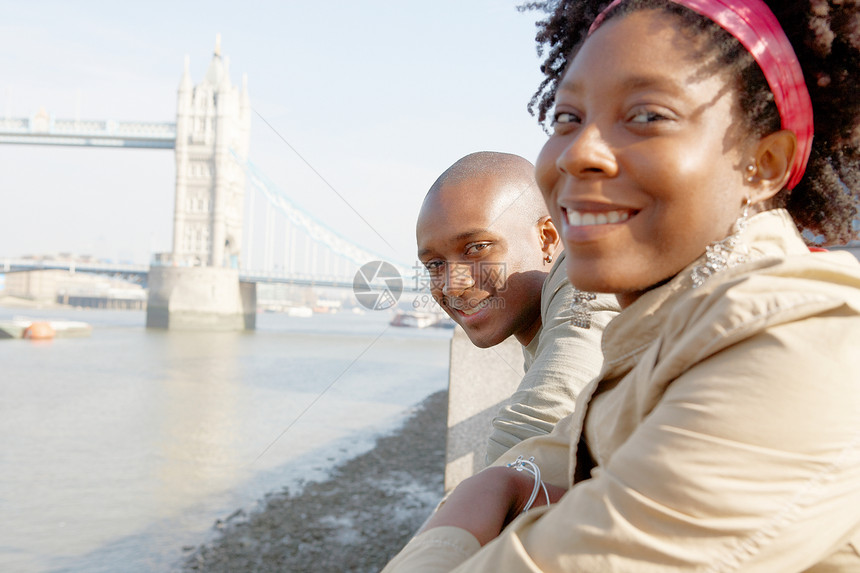 一对来到伦敦塔的非裔美国旅游情侣的肖像俯瞰河图片