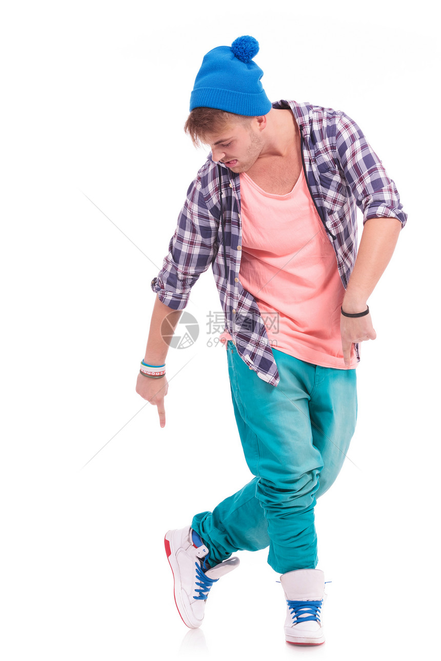 一个现代年轻男舞蹈家的肖像指着和看着他的鞋子用舌头伸出图片