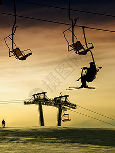 日落时在滑雪坡上方的滑雪电梯图片