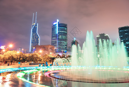 上海的广场晚上有喷泉和城市天际线图片