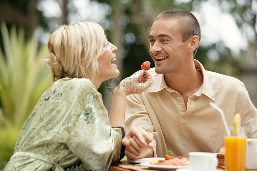 年轻夫妇在度假时在热带花园吃奢侈早餐图片