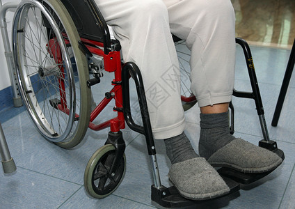 坐在轮椅上的腿有问题的老年患者图片