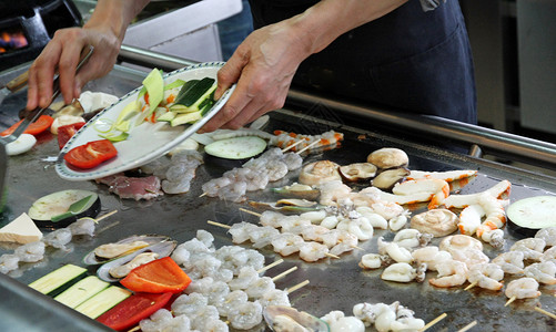 厨师在盘子里烤蔬菜鱼和肉图片